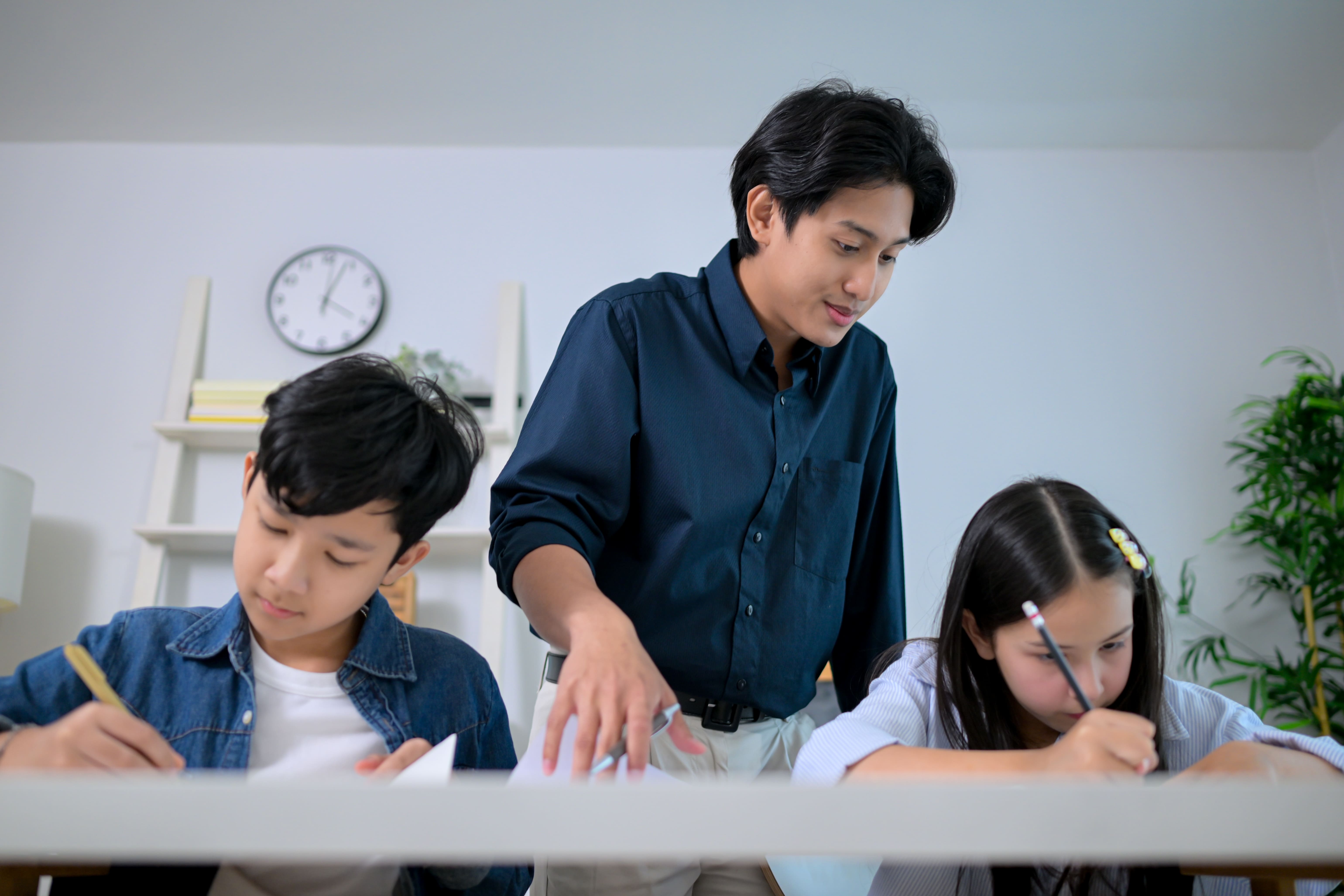 Teacher guiding students through problem-solving exercises during preparation for the gifted education programme.