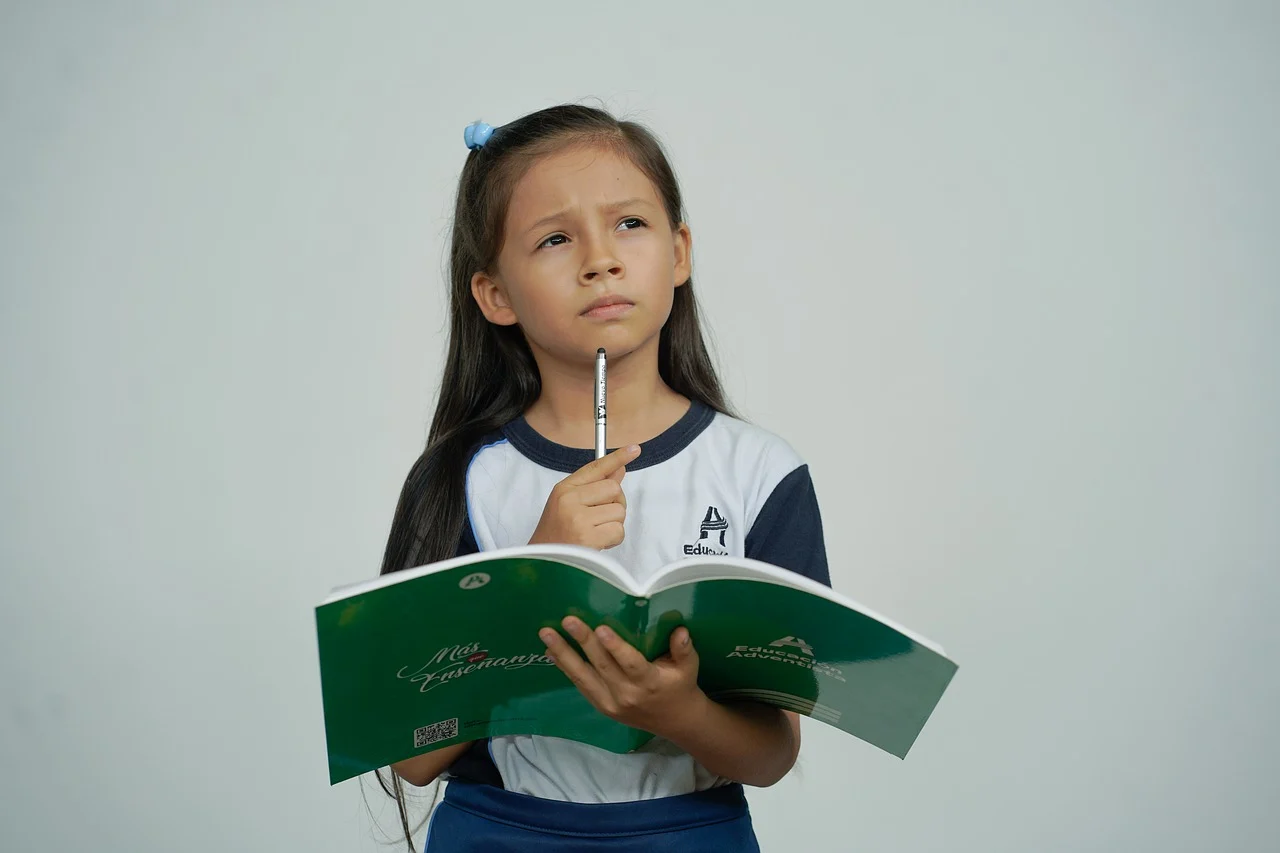 a child enrolled in a math olympiad programme holding an exercise book pondering a problem