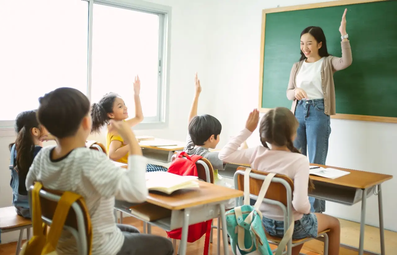 A tutor in front of a blackboard teaches students enrolled in a math olympiad programme