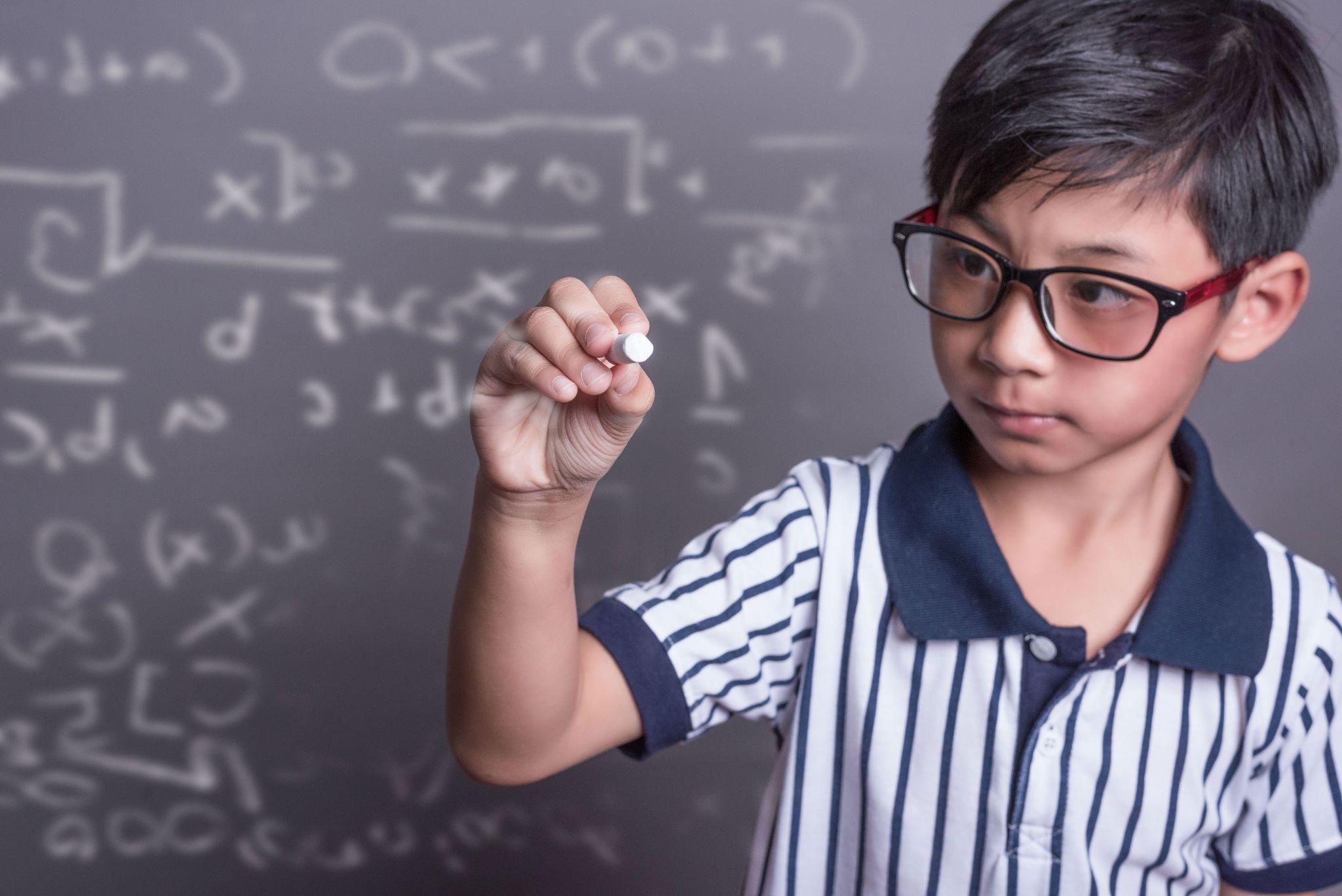 a kid solving algebraic equations on a blackboard as part of his math competition preparation